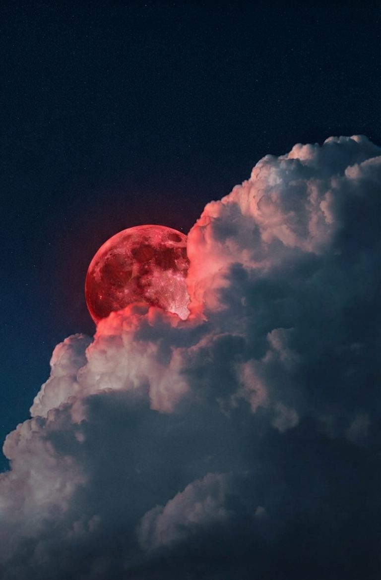 Sun behind a cloud against deep blue sky